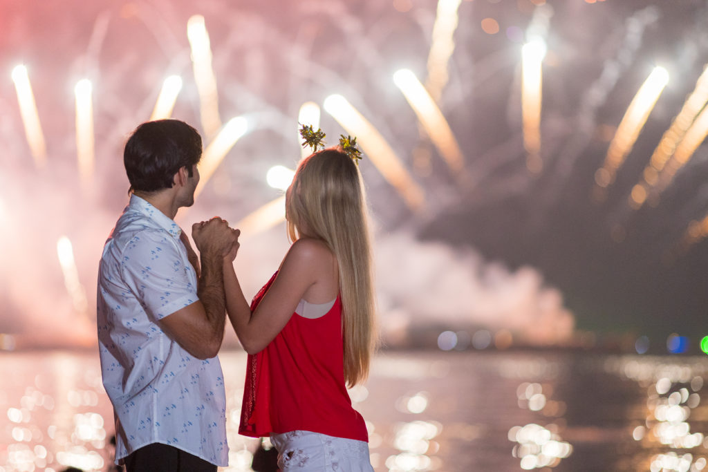 Young couple enjoy firework during celebration festival on the beach.