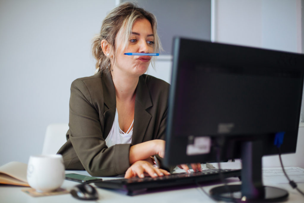 Woman bored at work, ignoring project deadlines.