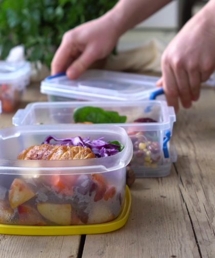 Young person placing single portions of food into containers to meal prep for the coming week