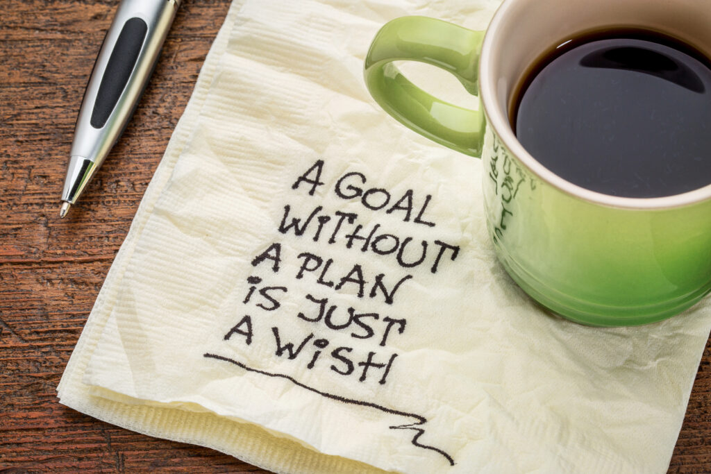 a goal without a plan is just a wish - motivational handwriting on a napkin with a cup of coffee