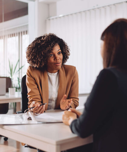 interview; job; young; business; people; female; sitting; work; woman; adult; happy; caucasian; corporate; worker; recruitment; employment; businesswoman; indoor; survey; hispanic; interviewing; executive; applicant; candidate; office; manager; colleague; bank; financial; consulting; banking; consult; team; business people; african; multi ethnic; meeting; two; day; smiling; talking; agent; desk; insurance; pension; client; presenting; formalwear;