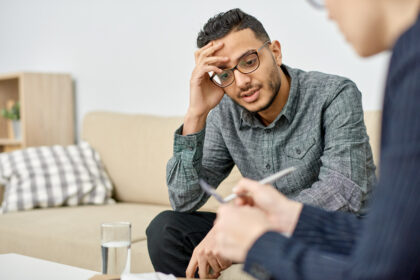 Young man leaning head against hand at therapist's office