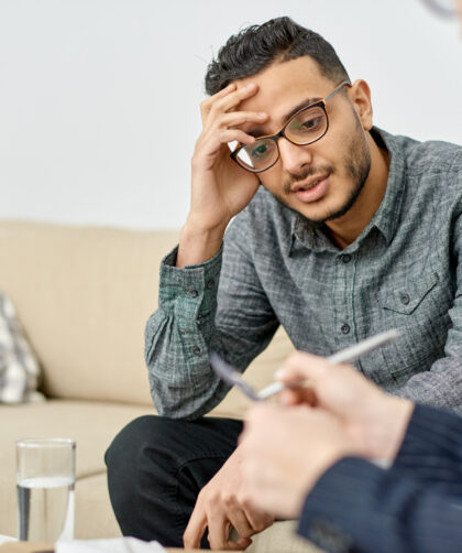 Young man leaning head against hand at therapist's office