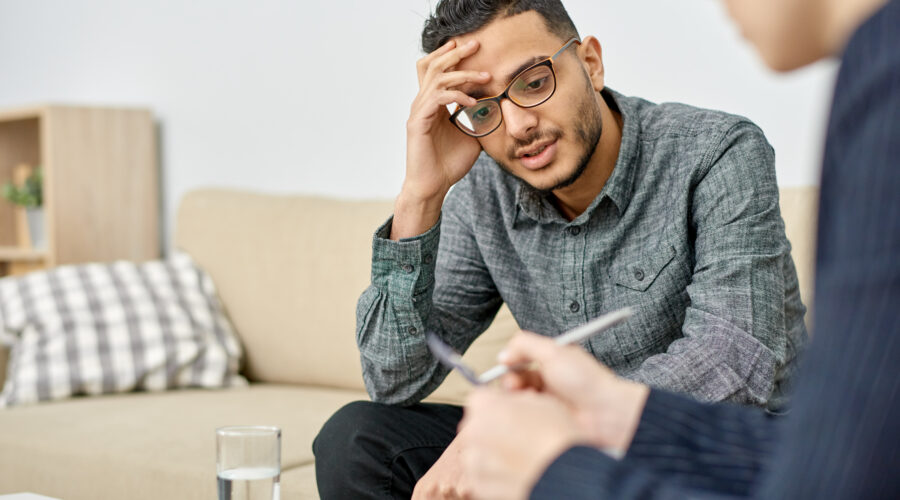 Young man leaning head against hand at therapist's office