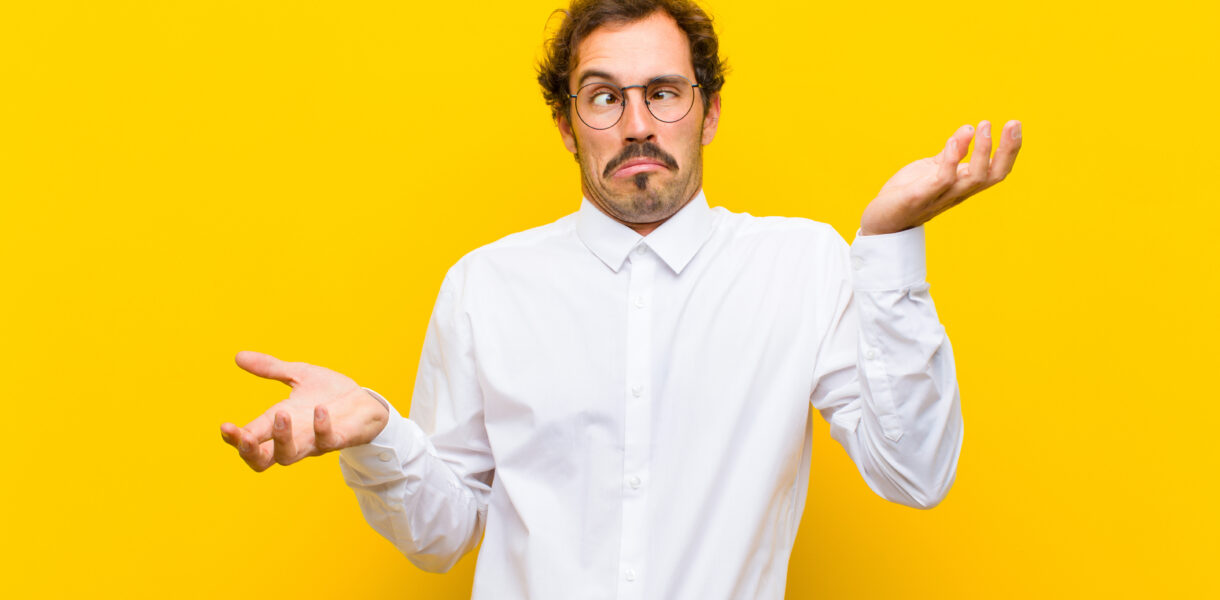 man shrugging with overly dramatic expression against a yellow background