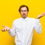 man shrugging with overly dramatic expression against a yellow background