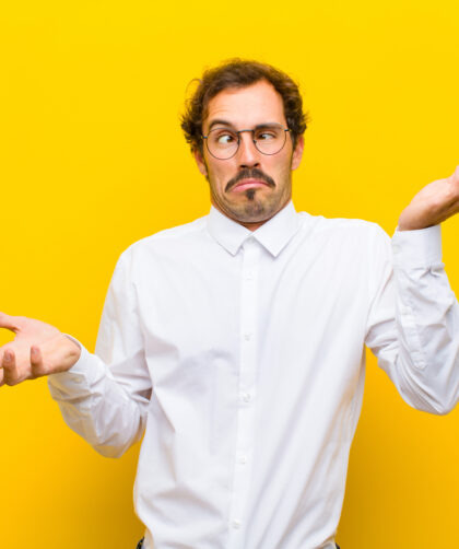 man shrugging with overly dramatic expression against a yellow background