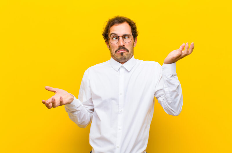 man shrugging with overly dramatic expression against a yellow background