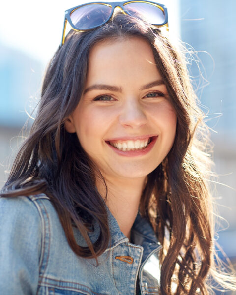 women and people concept - happy smiling young woman on summer city street