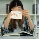 Asian student woman have anxiety because of exams, female hold help in the library. stress, despair, haste, misunderstanding reading, discouraged, expectation, knowledge