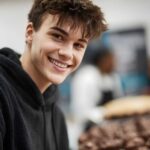 a young male teen with black hoodie smiling