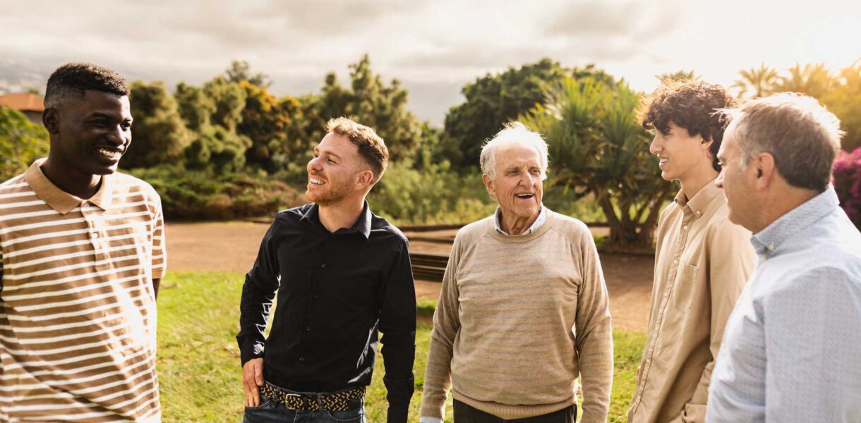 Happy multigenerational group of men with different ethnicities having fun in a public park