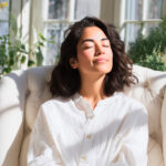 Relaxed woman enjoying sunlight indoors