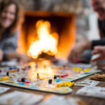unplug for the holidays, screen-free Thanksgiving, be present at Thanksgiving, digital detox tips, Family playing board games by fireplace after Thanksgiving dinner, cozy autumn vibe, laughter and fun